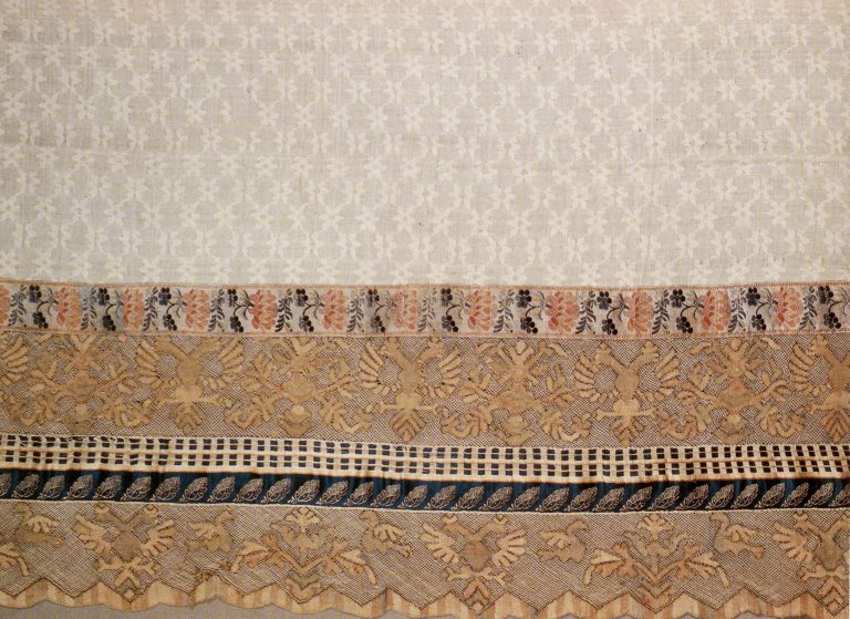 Towel edge. Fragment of multicoloured thread lace
